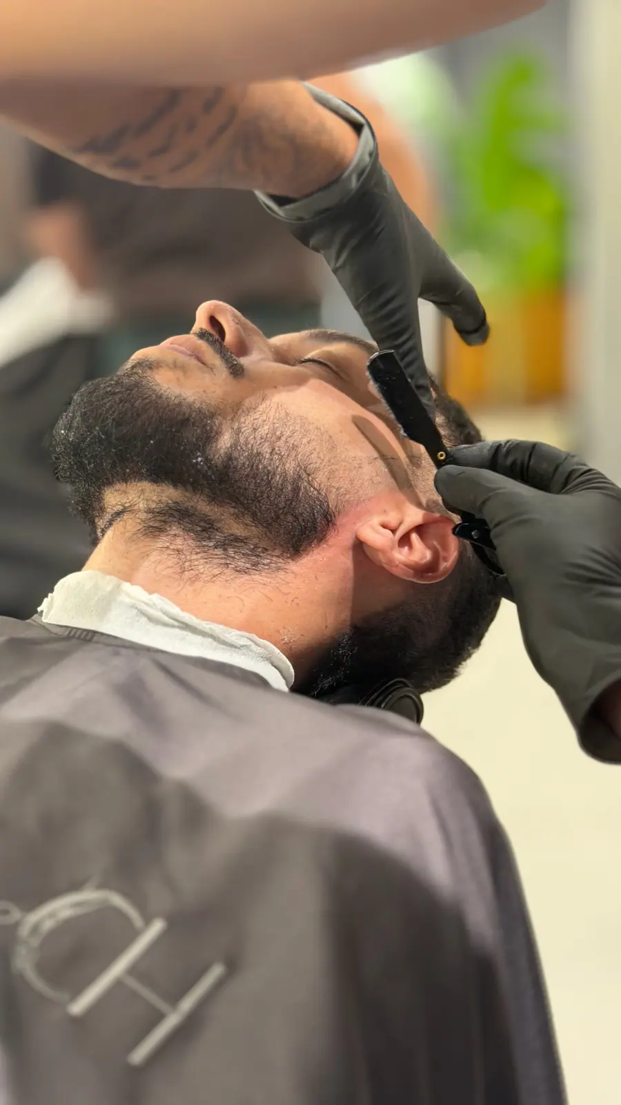 Barba sendo desenhada com navalha, em close