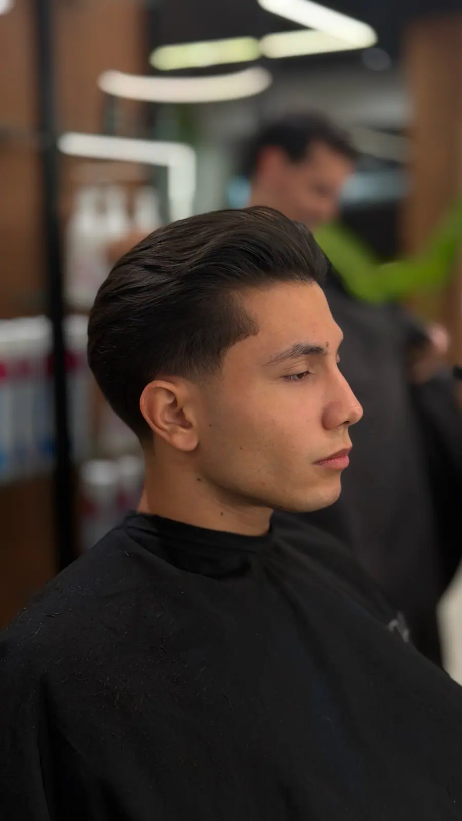 Resultado do corte, visto de perfil, com o cabelo penteado para trás